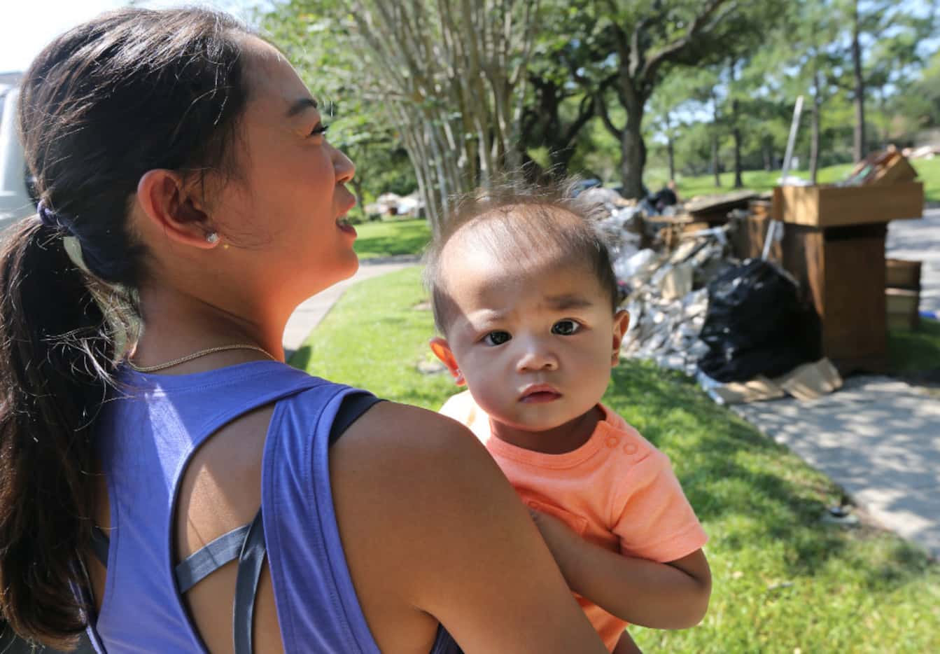 Catherine Pham and 13-month-old Aidan stand in their driveway and survey the scene as...