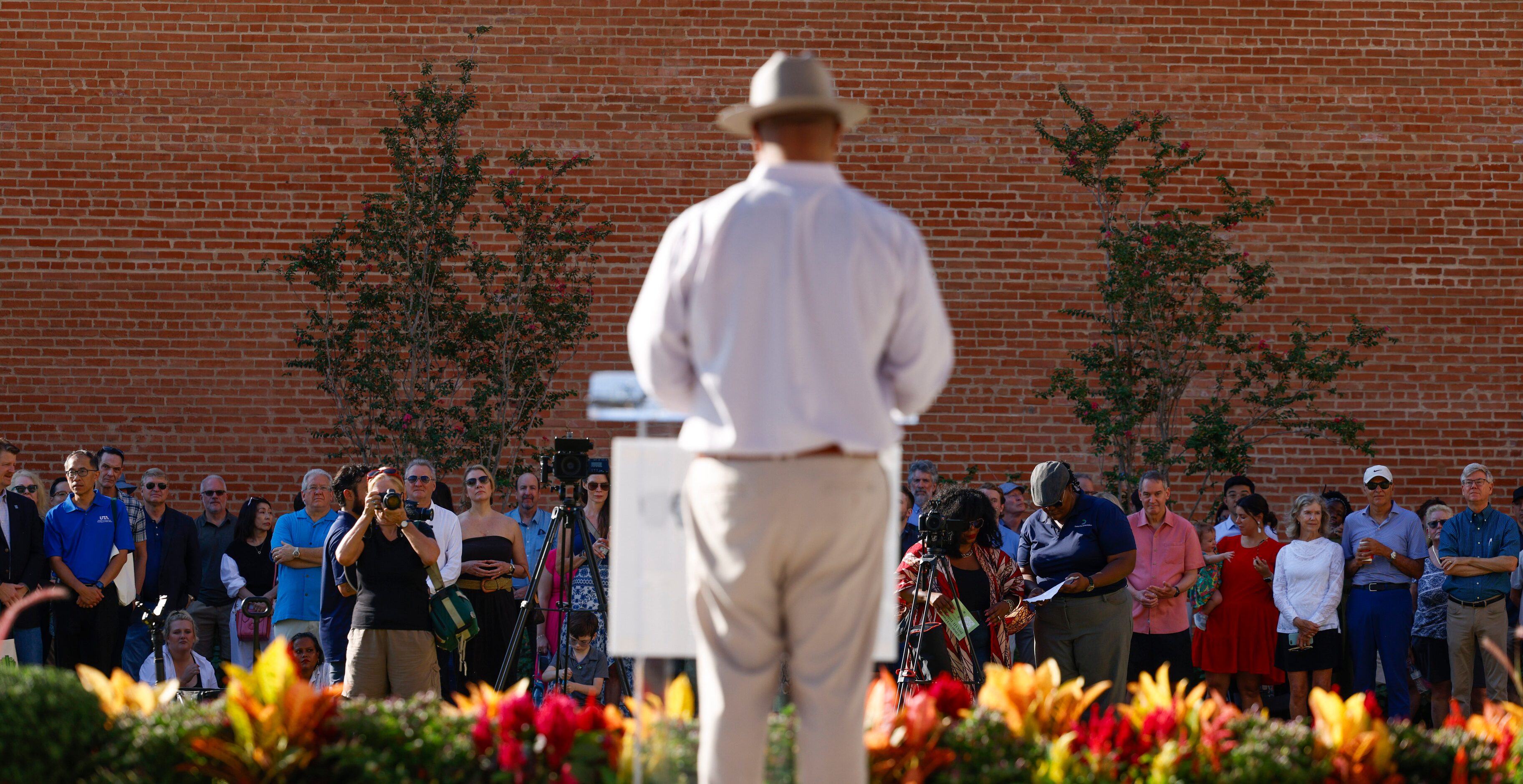 Attendees listen to Dallas Mayor Eric Johnson during the opening ceremony of Harwood Park,...