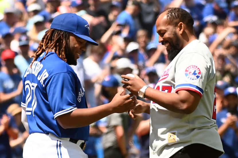 Toronto Blue Jays' Vladimir Guerrero, right, signs a baseball with his son, Vladimir...