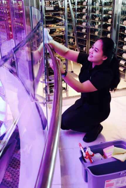 Yulia Asriyani cleans glass in the ship's atrium. She worked in a hotel in her native...