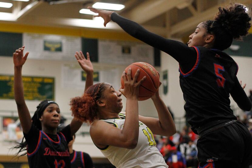 DeSoto's Tionna Herron (11), center, is challenged by the aggressive defense of...