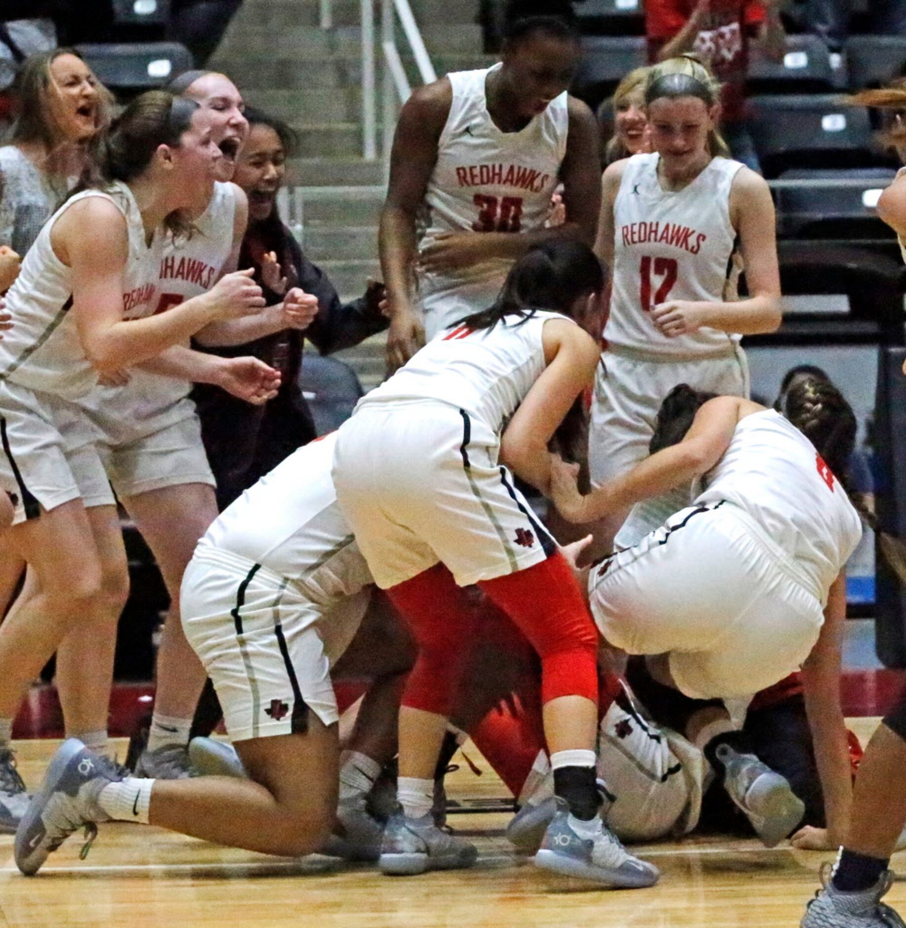 Liberty High School team members mob Liberty High School Randi Thompson (23) after she hit a...