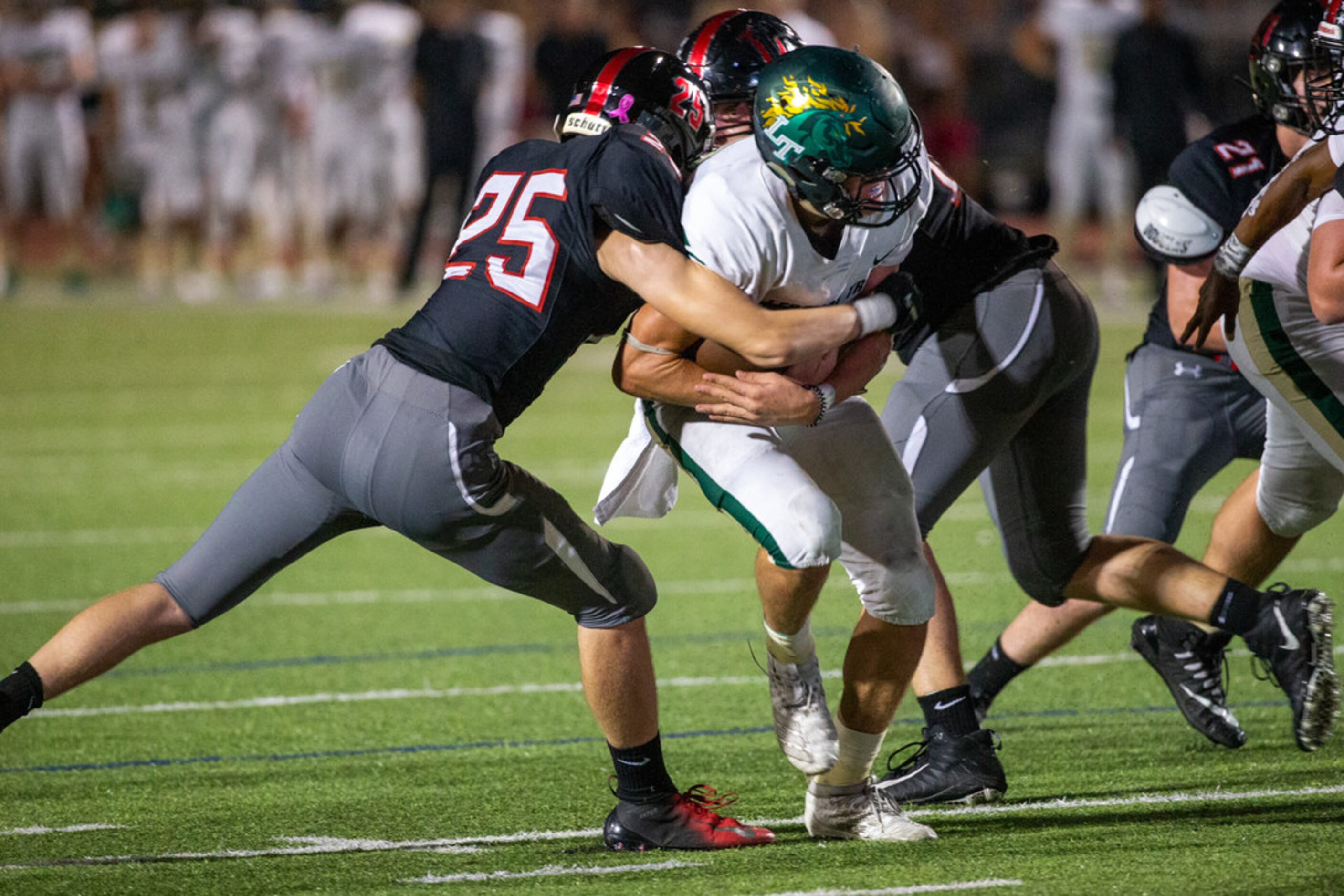 Lebanon Trail quarterback Drew Martin (17, center) pushes past defense to score a touchdown...