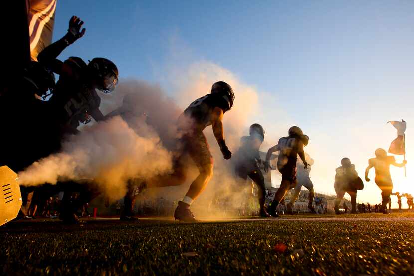 High school football players take the field before a game on Thursday, Sept. 29, 2022.