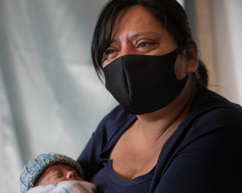 Miriam Palacios weeps as she holds her grandson, Isaiah, while recalling the death of her...