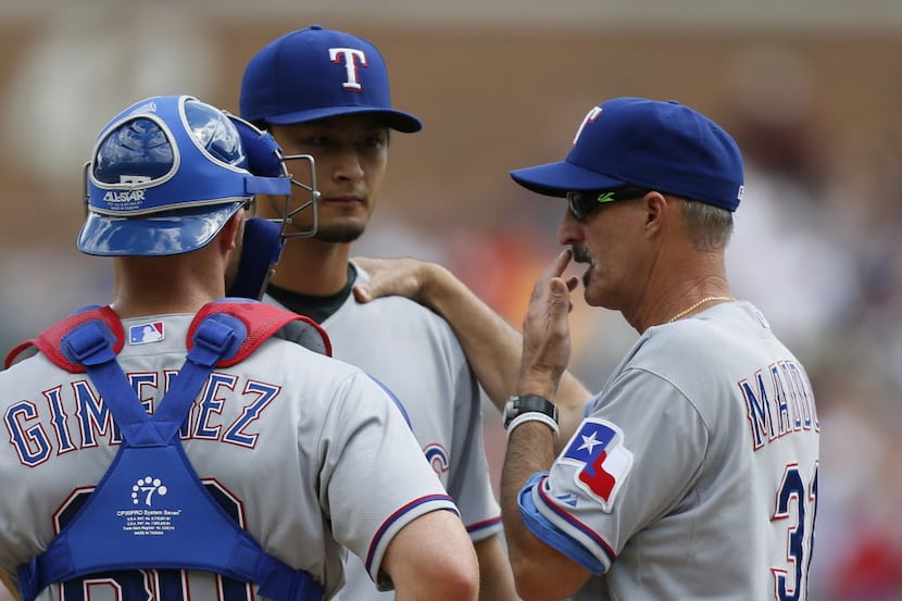 Texas Rangers pitching coach Mike Maddux, right, talks with starting pitcher Yu Darvish and...