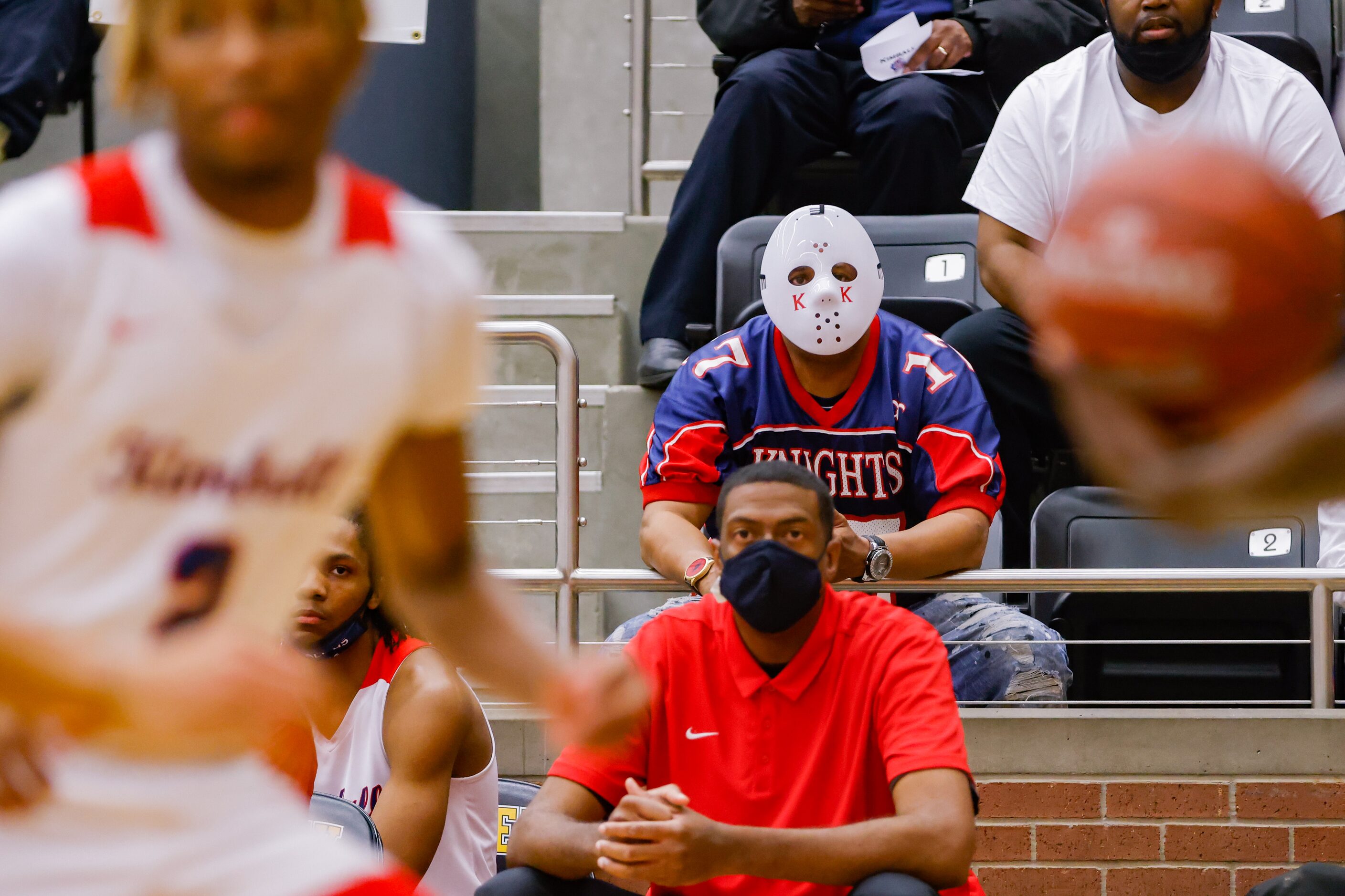 A Kimball fan wearing a goalie mask watches during the first half of a boys basketball UIL...