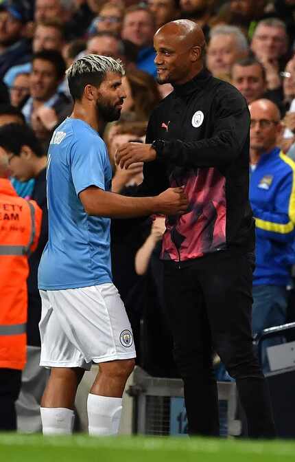 Manchester City Legend's forward Sergio Aguero (L) is congratulated by Former Manchester...