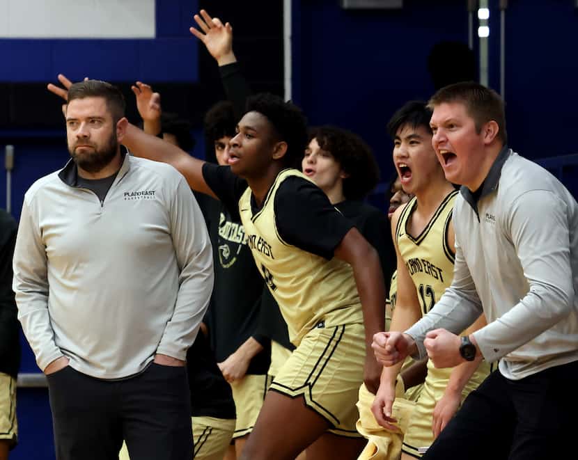 Plano East head coach Matt Wester, left, looks on as the Plano East bench reacts to a score...