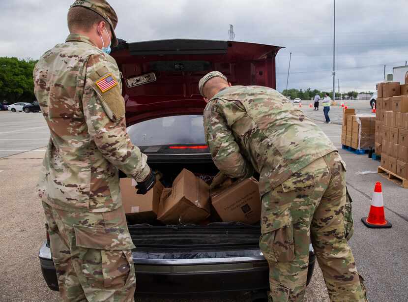 National Guard soldiers load Elise Earnhart Bigony's 1992 Cadillac Eldorado with food from...