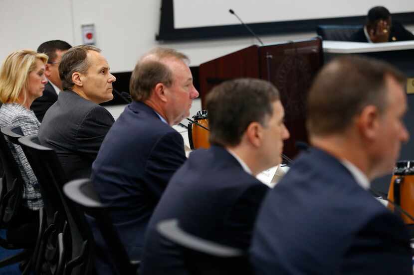 Atmos Energy's president and CEO Mike Haefner (in focus on left) listens at a city council...
