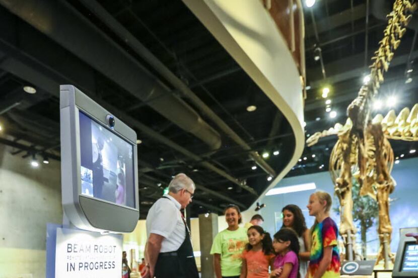 Docent Gerald Cornelius explains a Beam robot to visitors at the Perot Museum of Nature and...