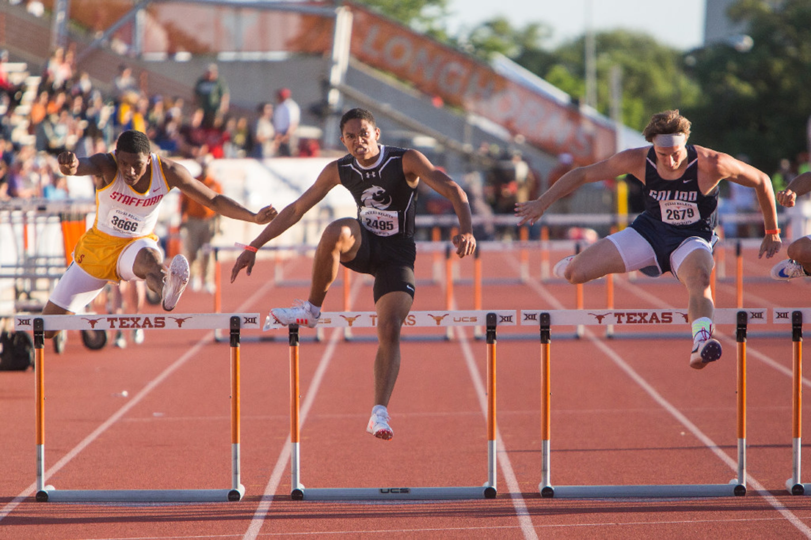 Denton Guyer's Javan Reece, center, races to the finish line in the 300 meter hurdles during...