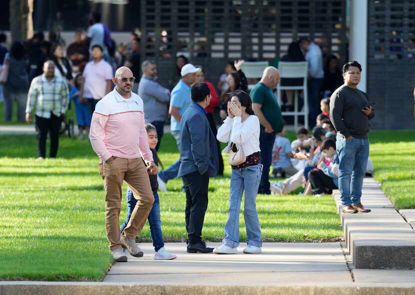 A woman wipes her face as she waits with others outside Lakewood Church in Houston on...