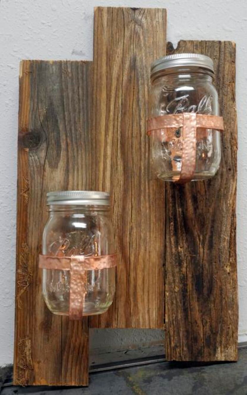 
Hand-hammered copper banding affixes Mason jars to reclaimed wood (right) to create a...