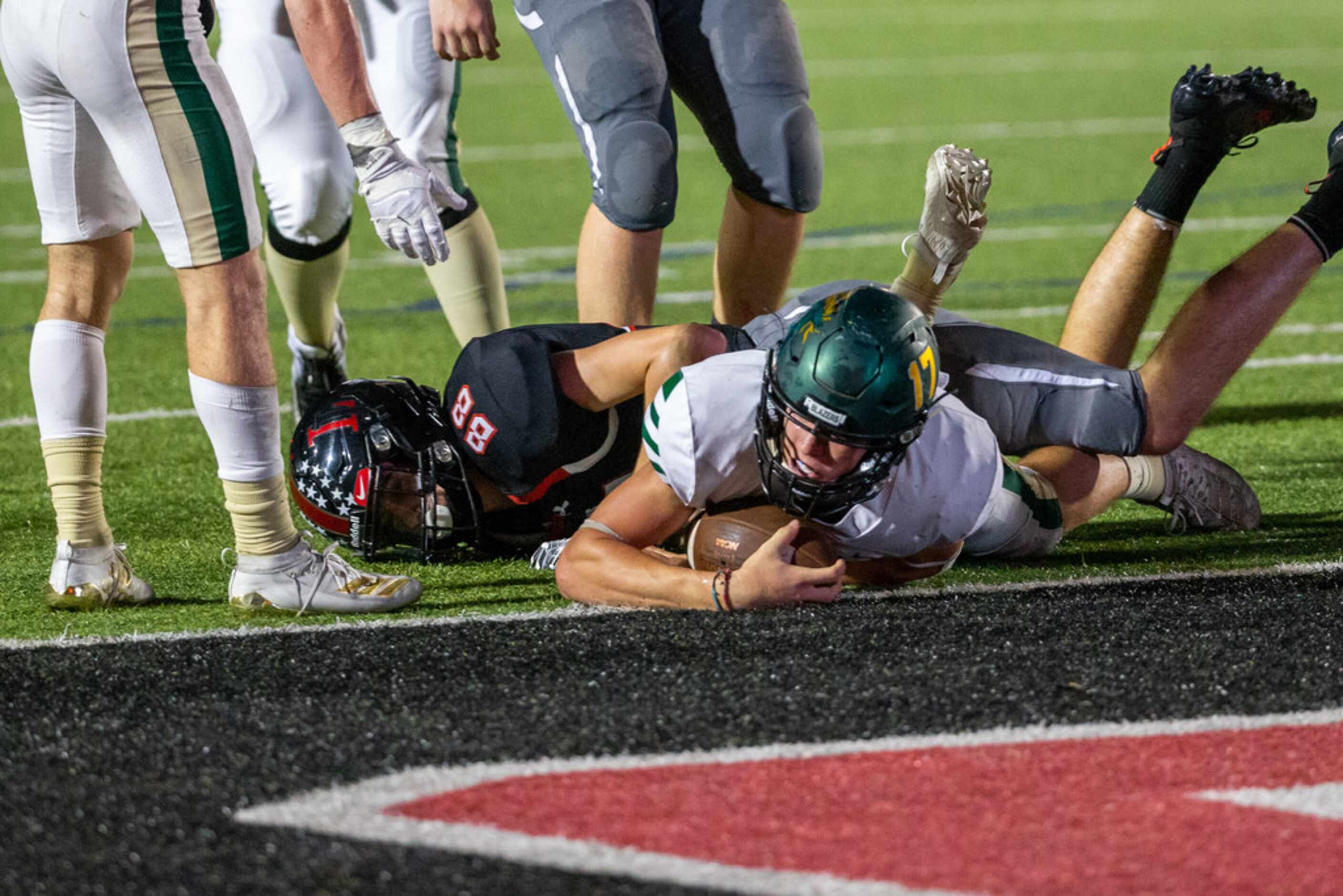 Lebanon Trail quarterback Drew Martin (17, center) pushes past defense to score a touchdown...