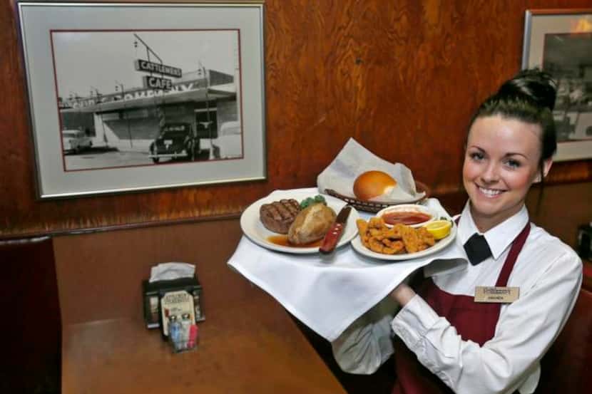 
Cattlemen’s server Amanda Jackson holds a tray with a beef filet, baked potato and lamb...