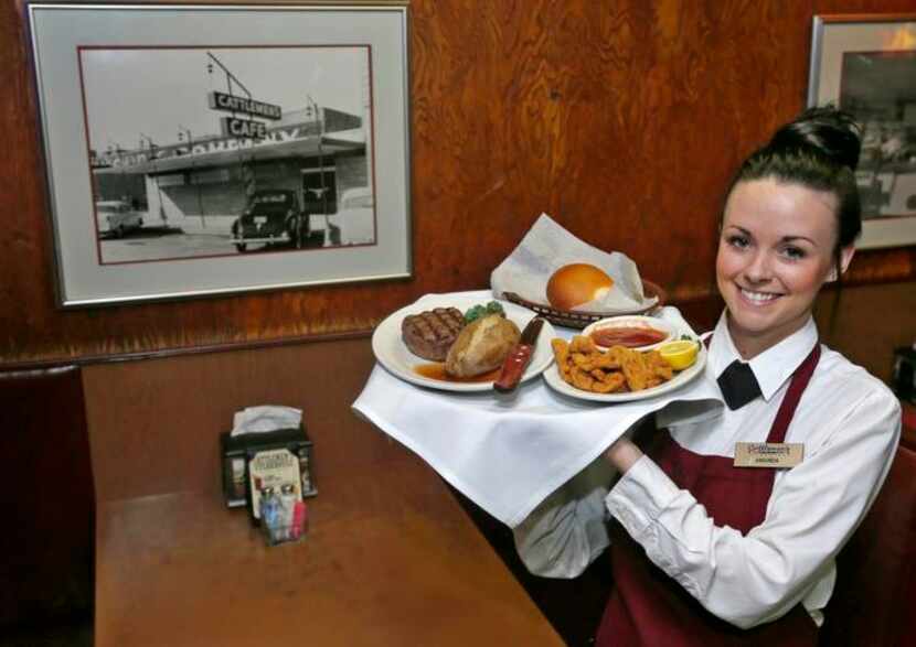 
Cattlemen’s server Amanda Jackson holds a tray with a beef filet, baked potato and lamb...