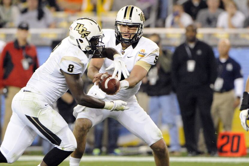 UCF Knights quarterback Blake Bortles (5) hands the ball off to running back Storm Johnson...