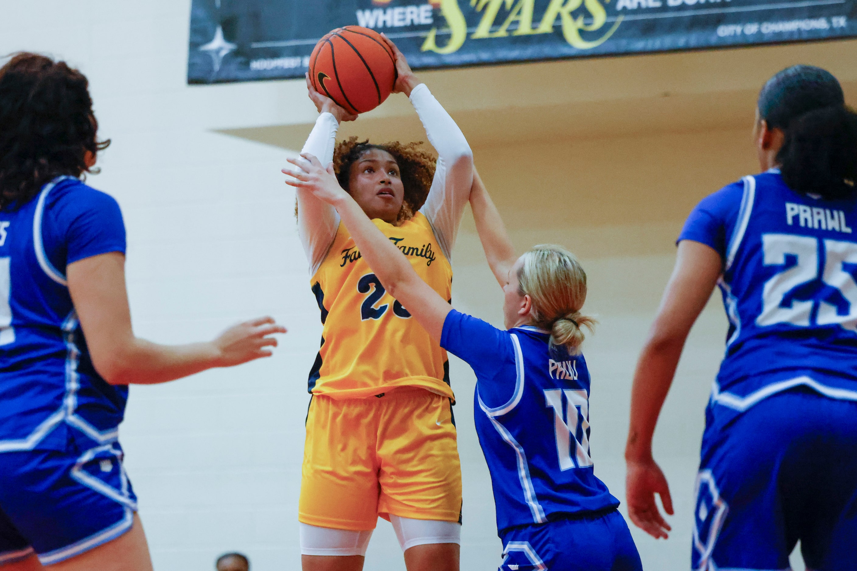 Oak Cliff Faith Family Academy’s Amayah Garcia (center) shoots over IMG Academy’s Georgia...