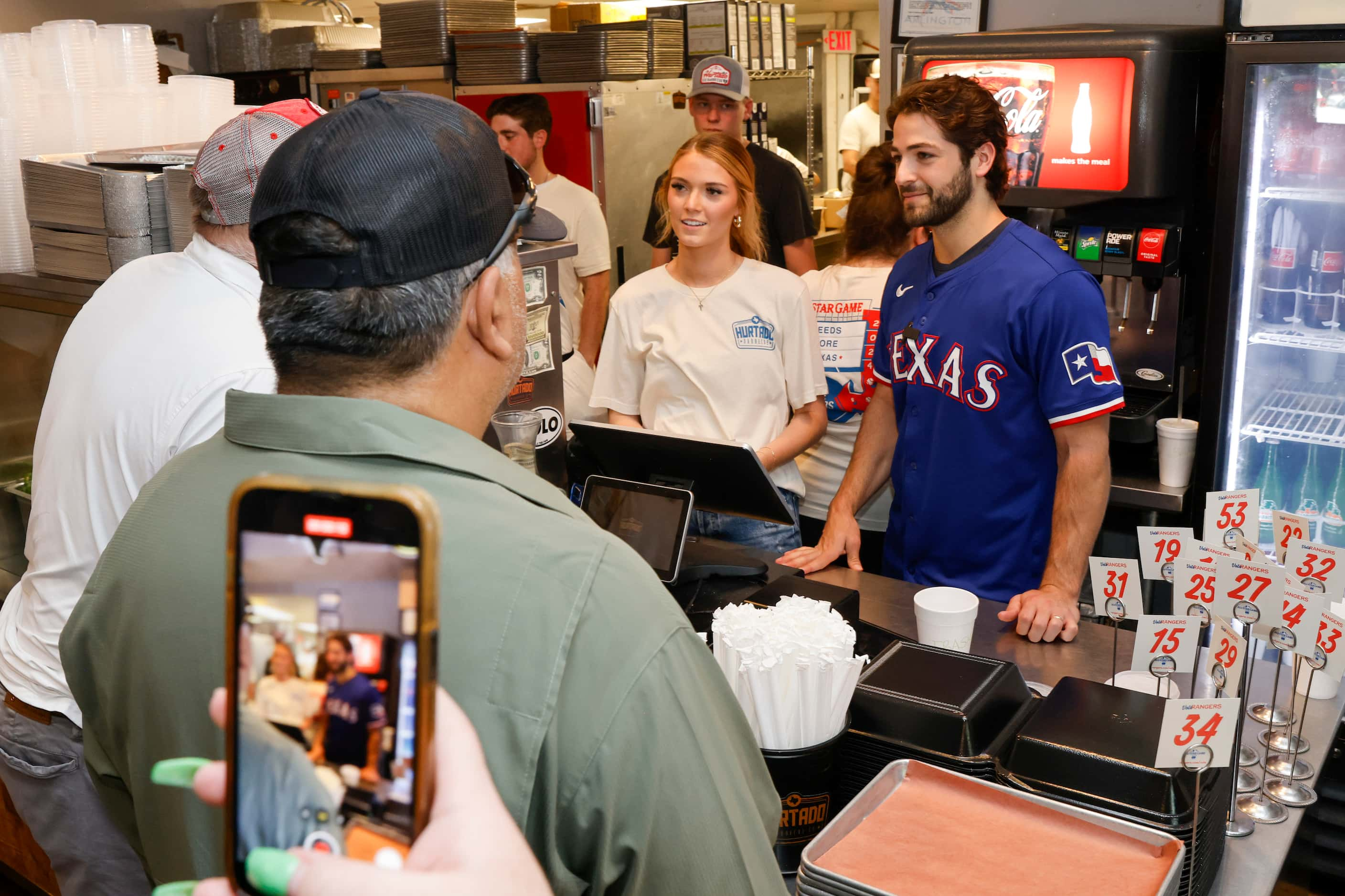 Texas Rangers third baseman Josh Smith rings up customers at the register with help from...