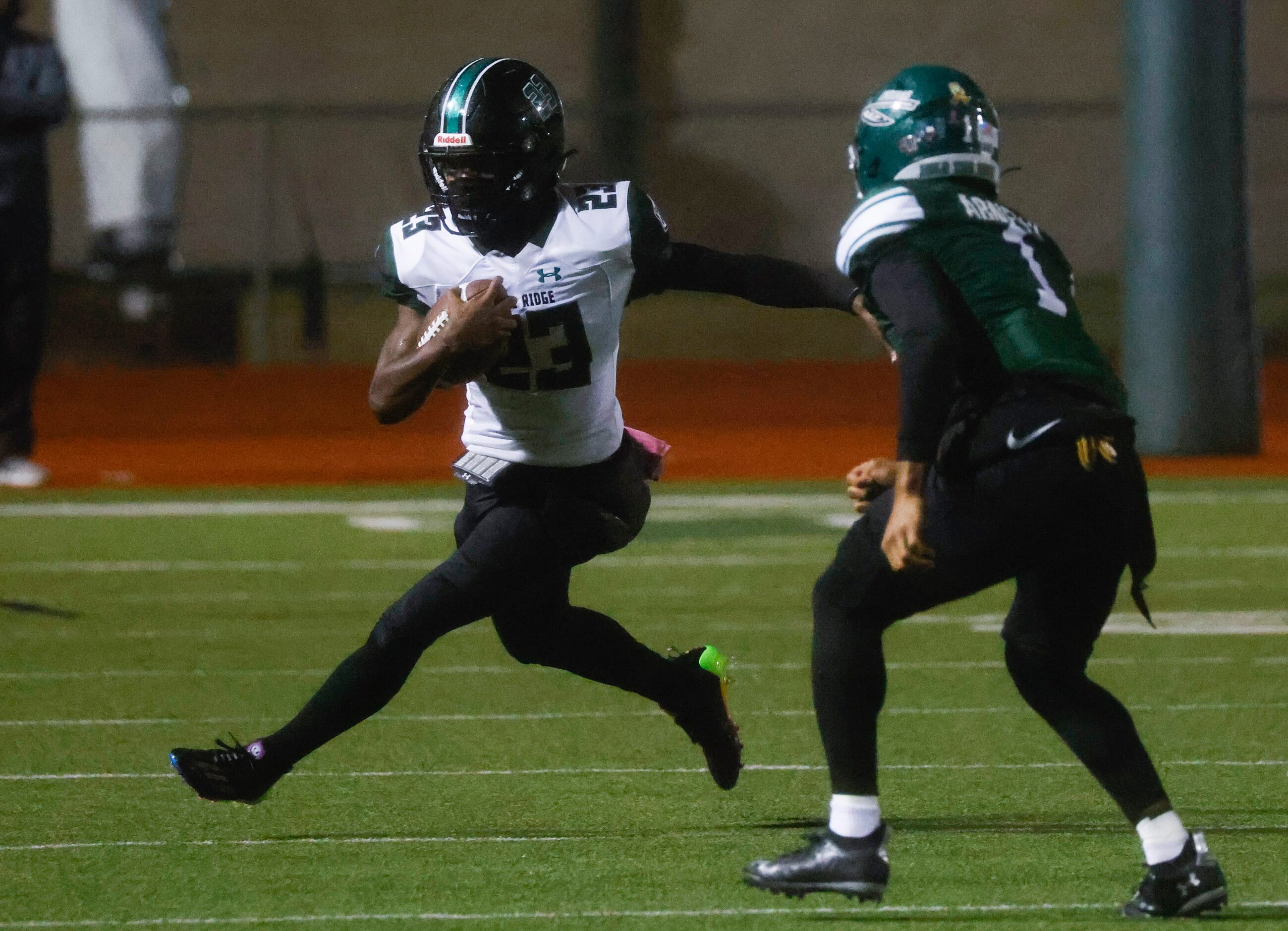 Mansfield Lake Ridge High School’s Raycine Guillory (23), left, runs past Waxahachie High...