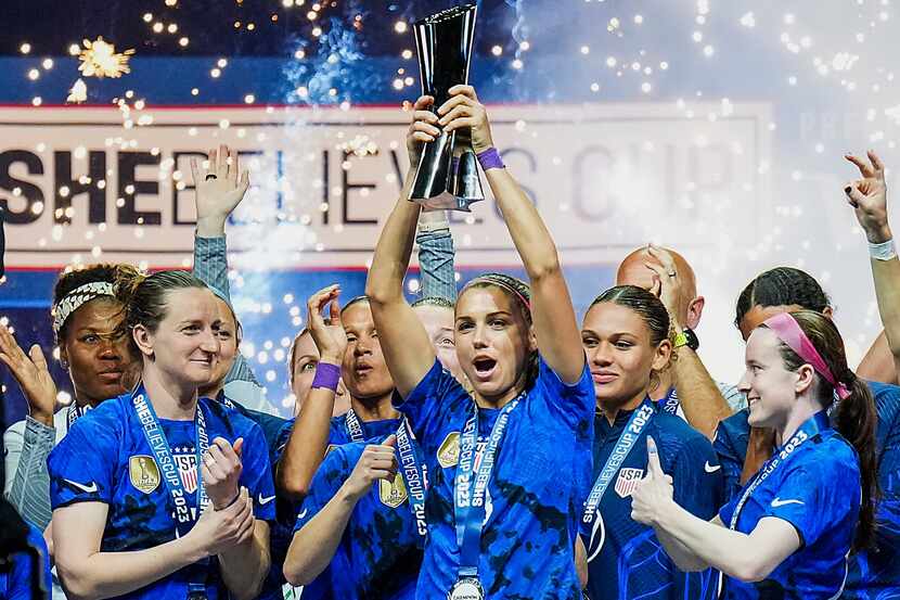 United States forward Alex Morgan (13) raises the trophy after a victory over Brazil in the...