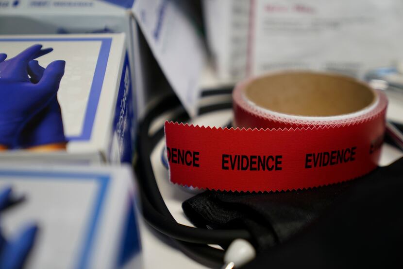 Evidence tape is seen with a Sexual Assault Evidence Collection Kit in an examination room,...