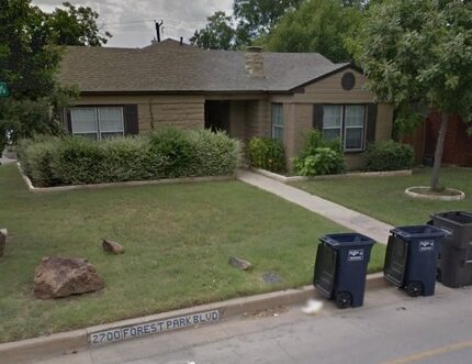 "2700 Forest Park Blvd" is written on the curb in front of the house, which has a different...