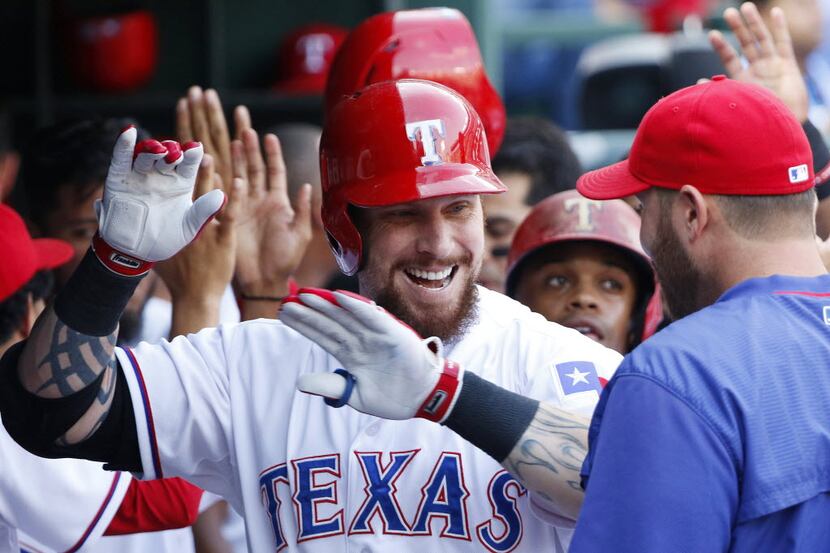 Texas Rangers left fielder Josh Hamilton (32) celebrates his 3-run home run in the dugout in...