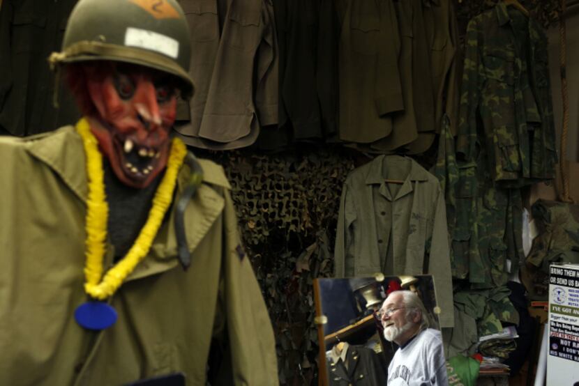 The Recon Militaria store owner D.J. Goodwin is reflected in a mirror in his store that...