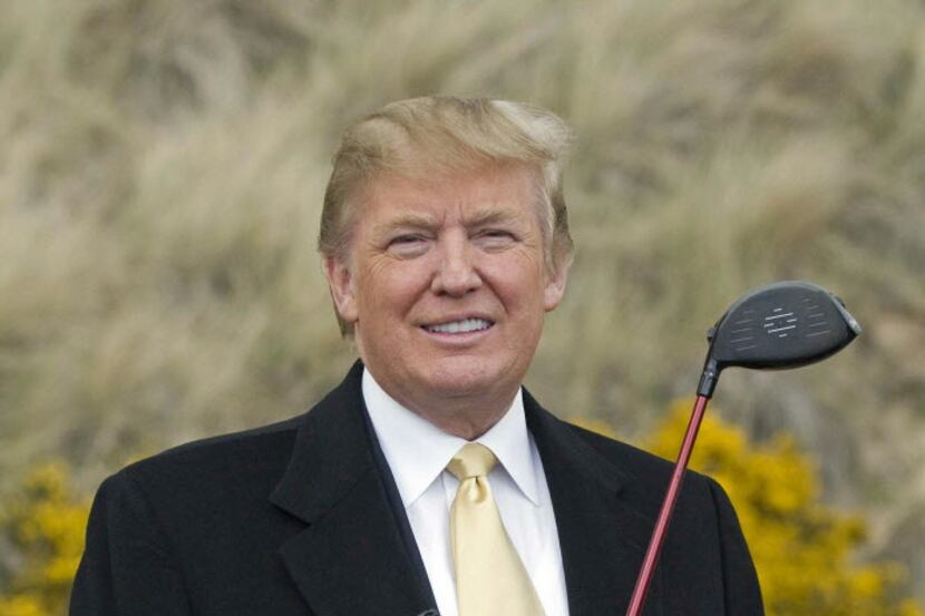 U.S. tycoon Donald Trump poses for photographers with a golf club duiring a visit to the...