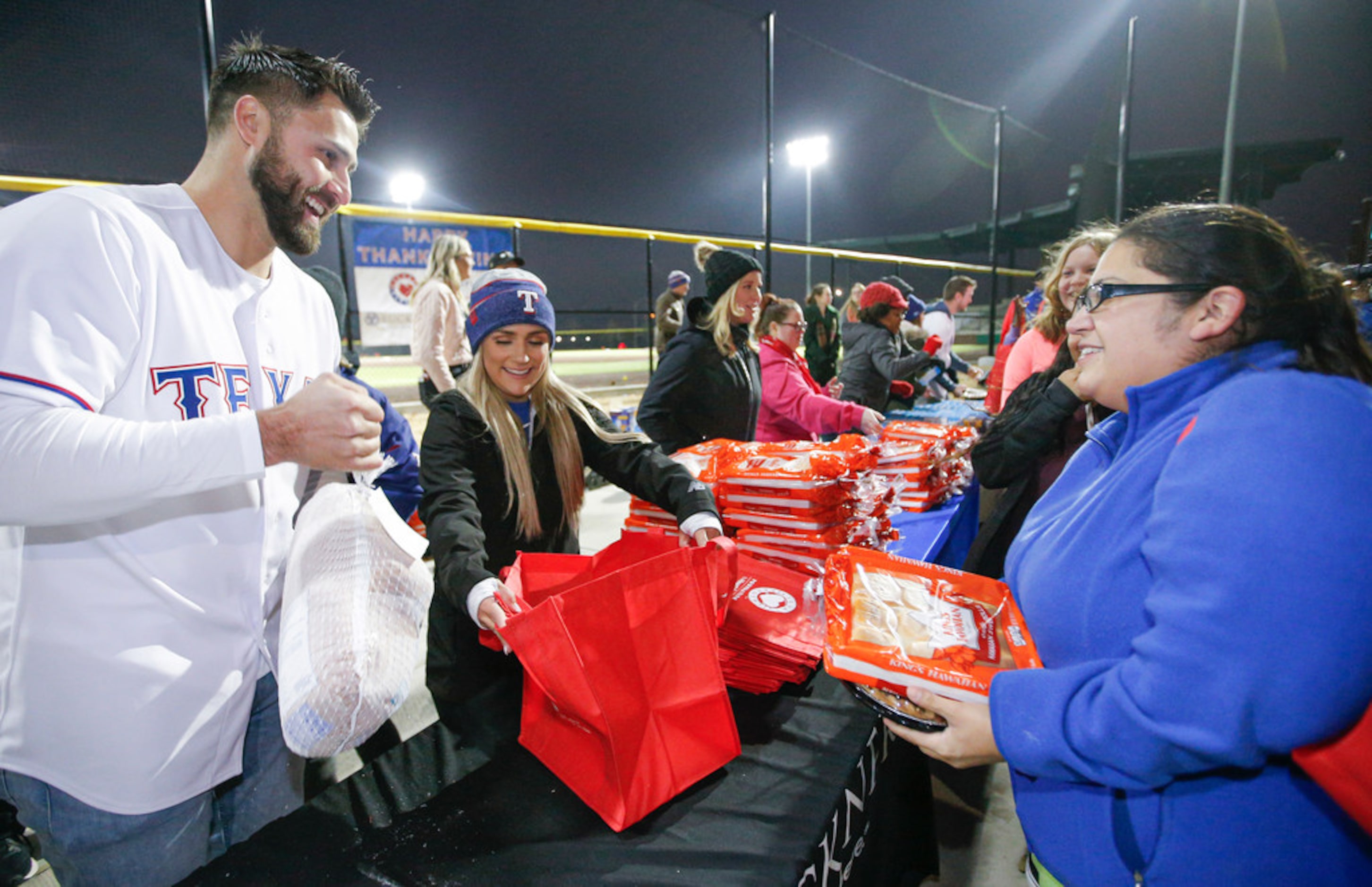 Texas RangersÃ Joey Gallo bags a frozen turkey for Erica Cortez, right, at the Texas...