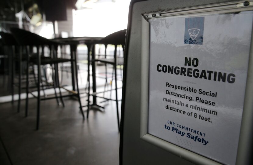 A sign is displayed encouraging social distancing at Topgolf in The Colony, on Friday, May...