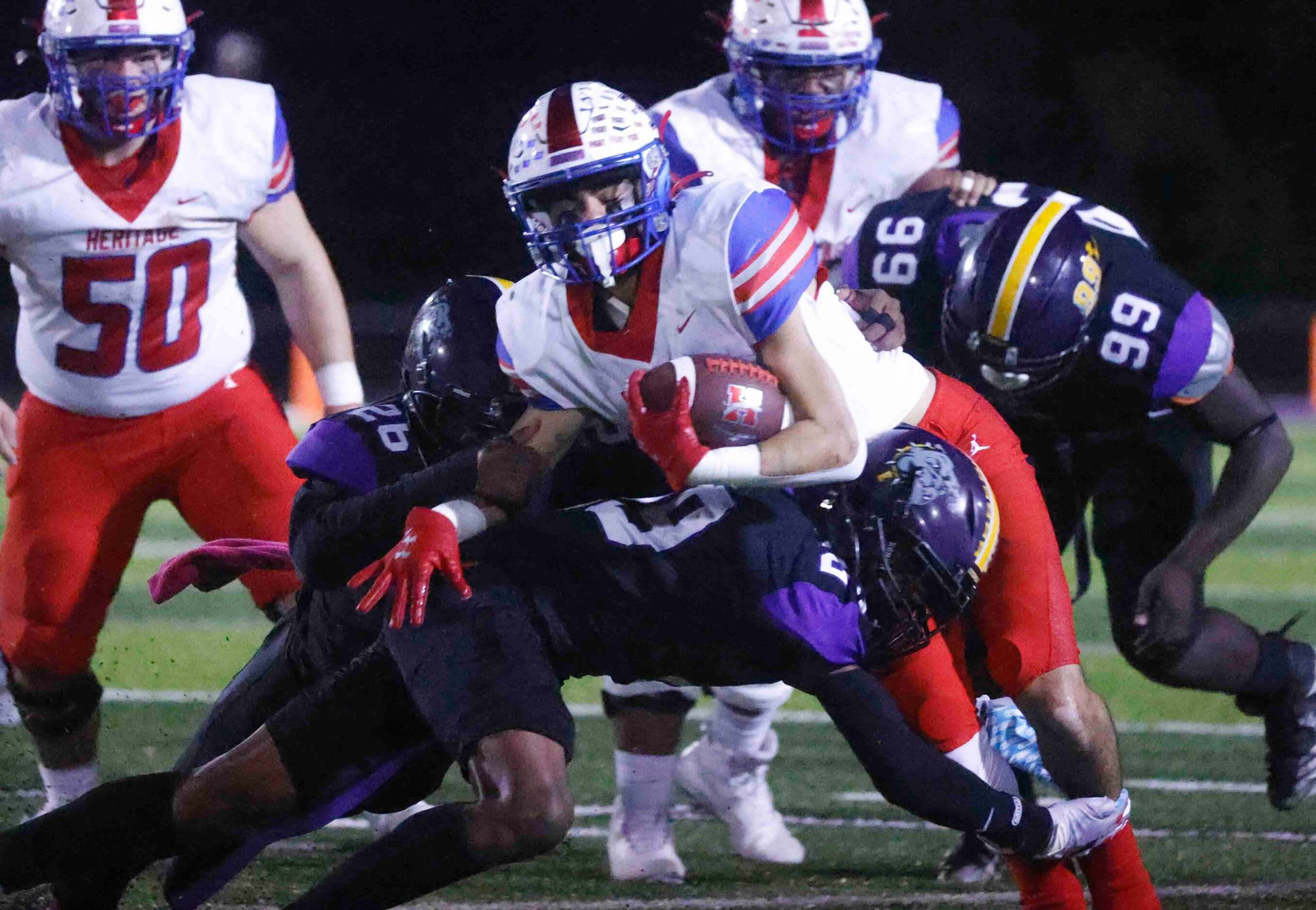 Midlothian Heritage’s Jason Barely (3), center, gets tackled by Everman High’s Jamarcus...