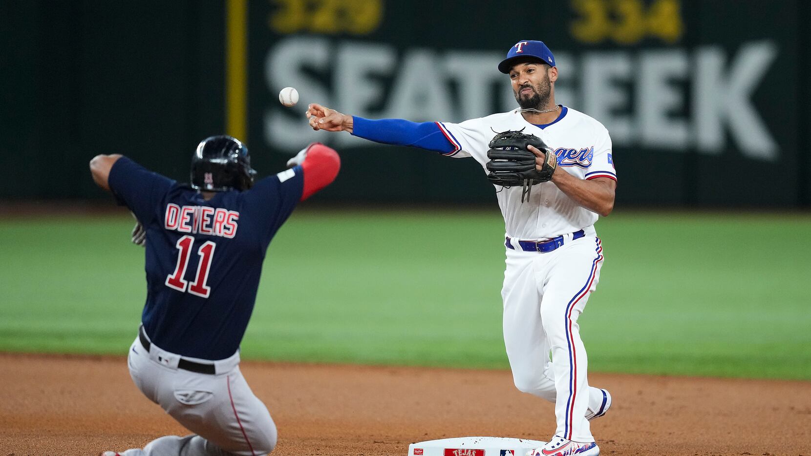 Texas Rangers second baseman Marcus Semien (2) turns a double play over Boston Red Sox third...