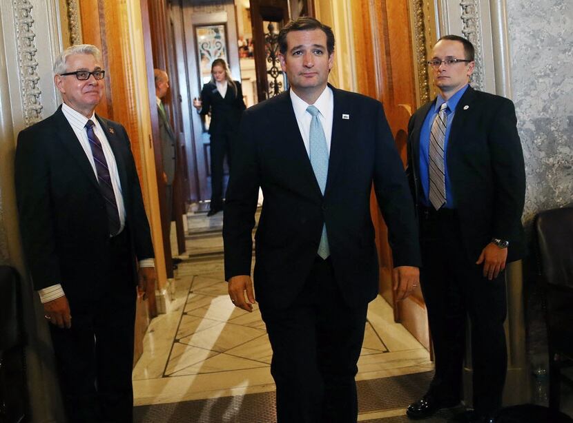 Sen. Ted Cruz walks off the Senate floor after a marathon speech opposing the Affordable...