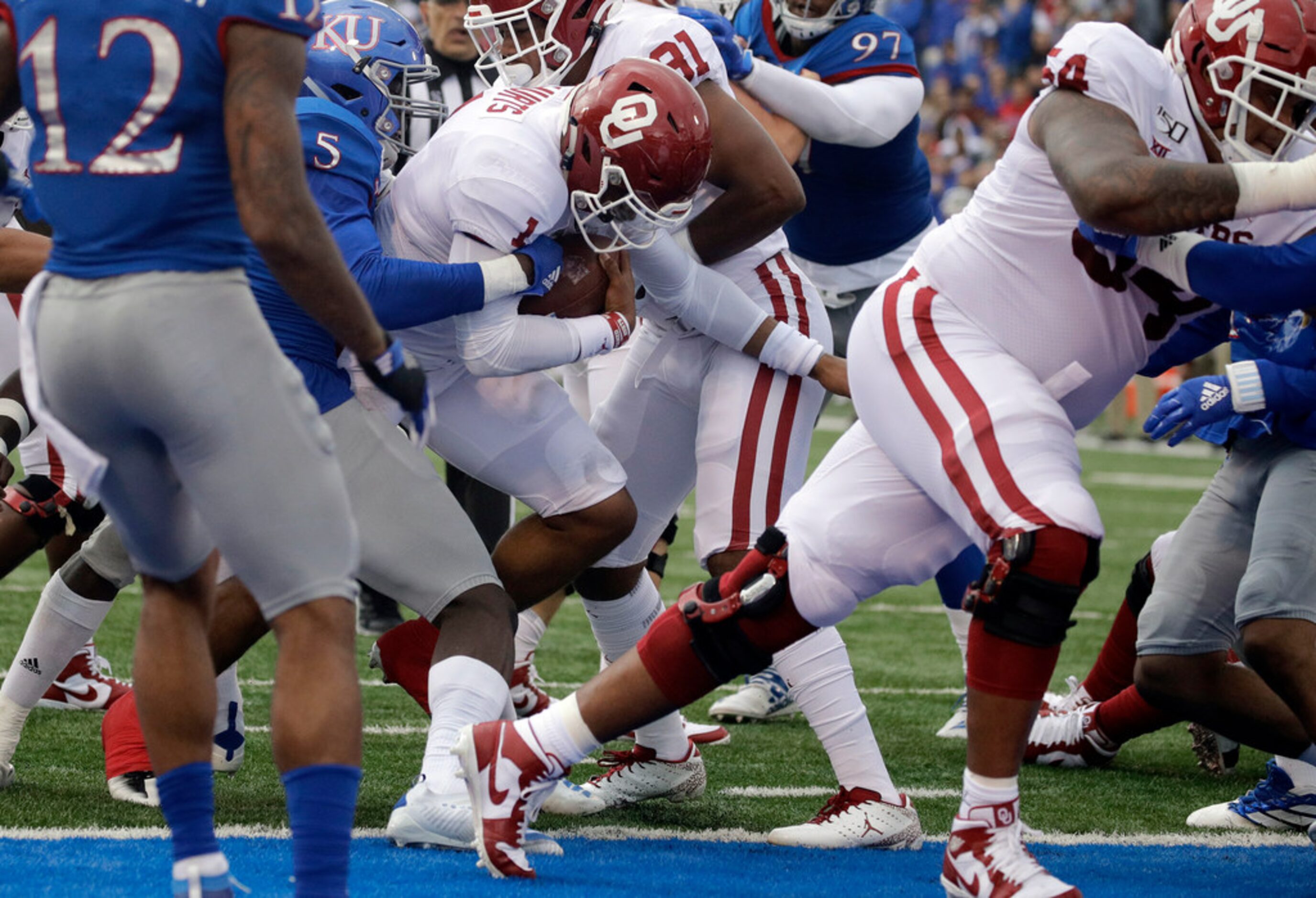 Oklahoma quarterback Jalen Hurts, center, runs into the end zone to score a touchdown during...