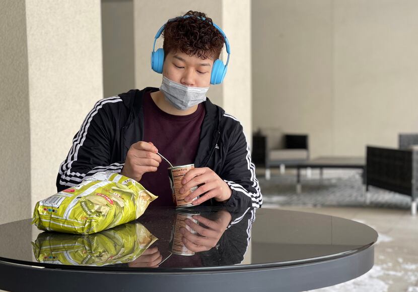 Jacky Chan eats a can of beans he warmed up on his apartment complex's gas grill in an...