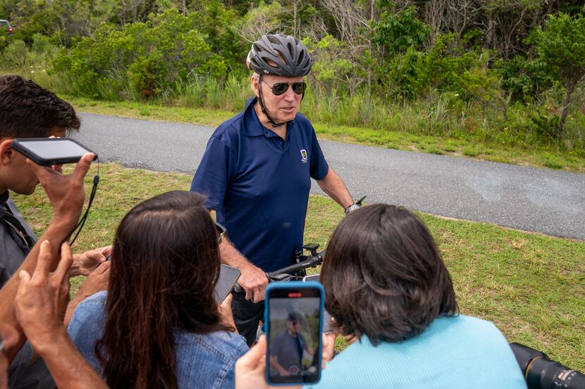 President Joe Biden speaks to members of the media as he goes on a bike ride in Gordons Pond...