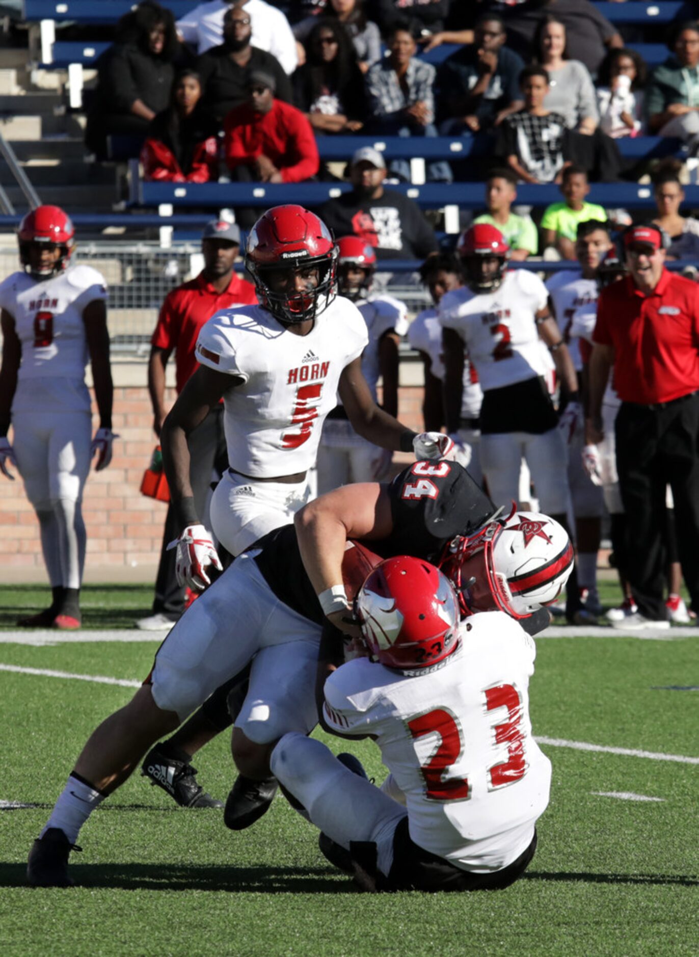 Coppell player 34, Ryan Hirt, is tackled by Horn player23, Oric Walker, during a Class 6A...