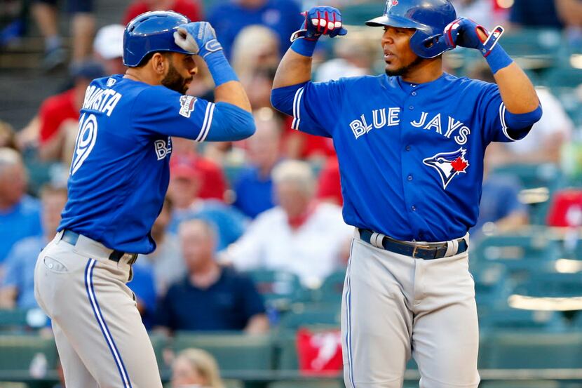 Toronto Blue Jays designated hitter Edwin Encarnacion (right) flexes his muscles to...