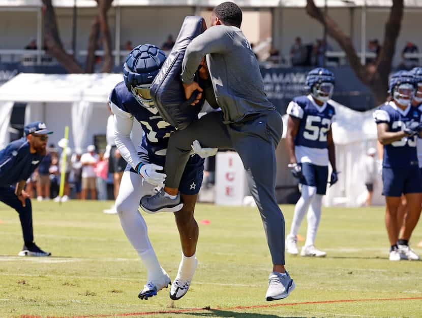 Dallas Cowboys linebacker DeMarvion Overshown (13) puts a hit on a coach as he practices...