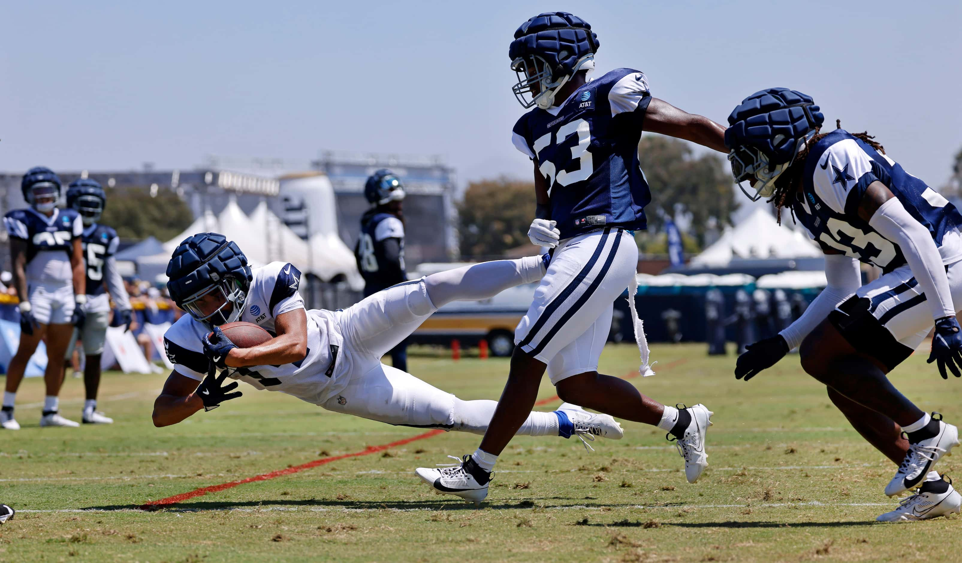 Dallas Cowboys wide receiver Cam Johnson (14) dives for yardage as he’s covered by...