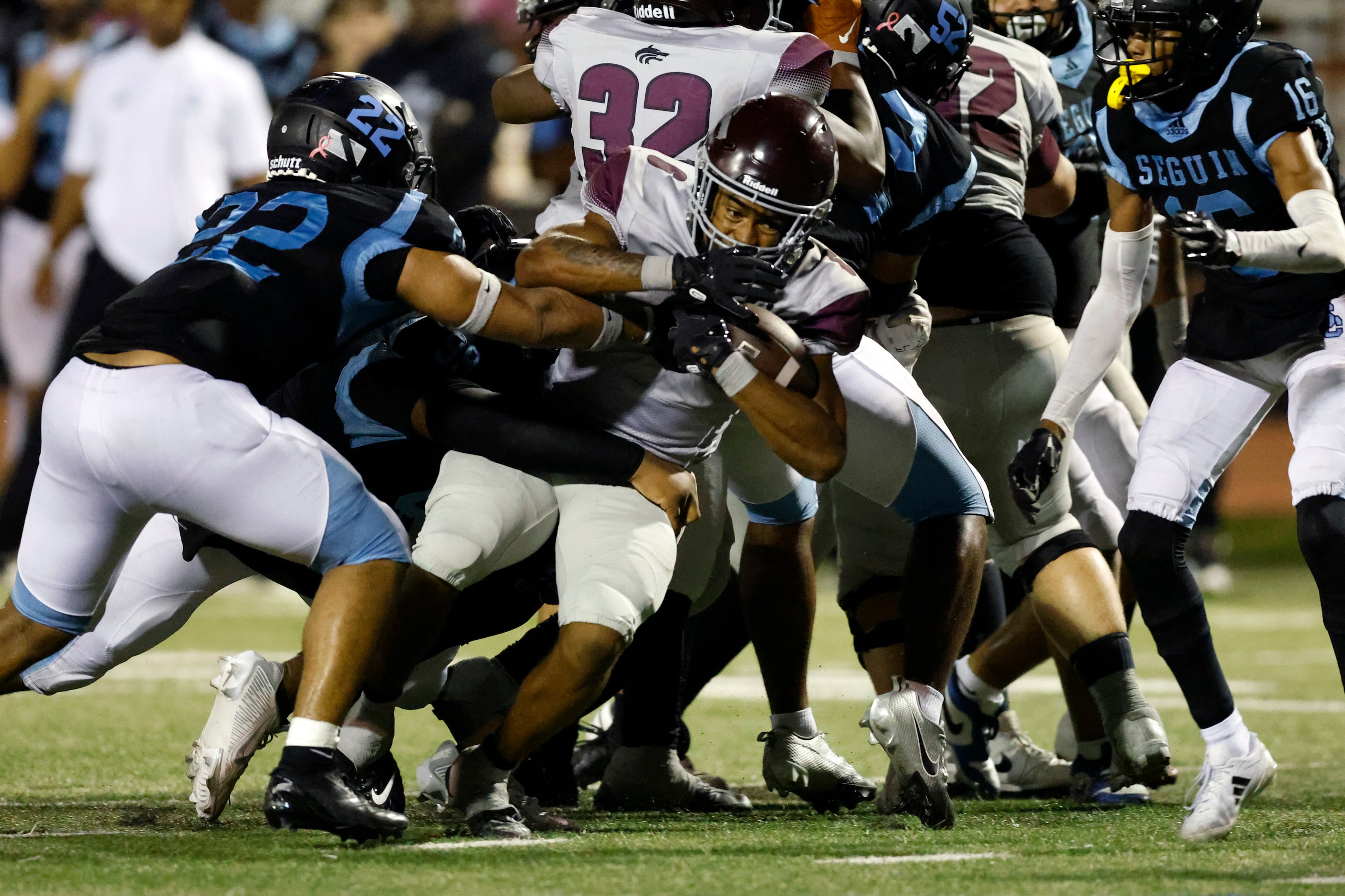 Arlington Seguin defensive linemen KJ Halloway (99) and Damien Cheathem (22) tackle...