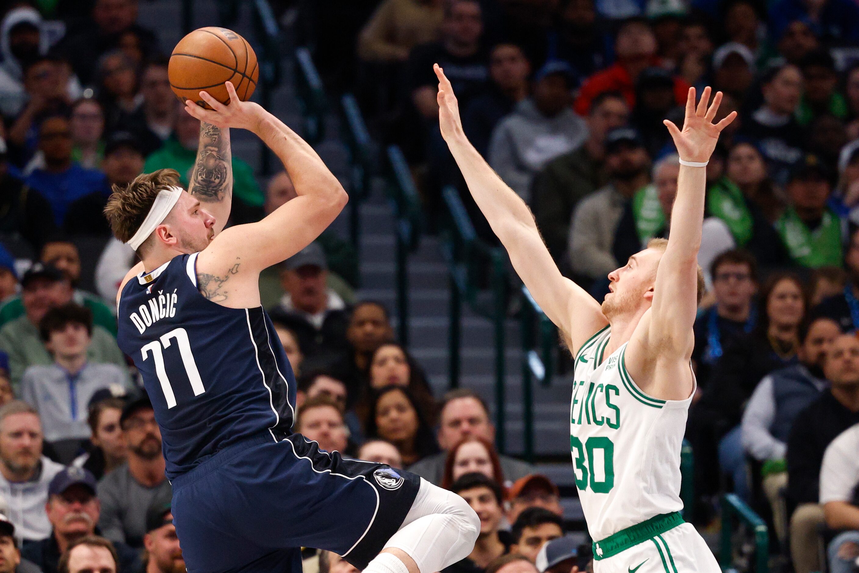 Dallas Mavericks guard Luka Doncic (77) shoots over Boston Celtics forward Sam Hauser (30)...