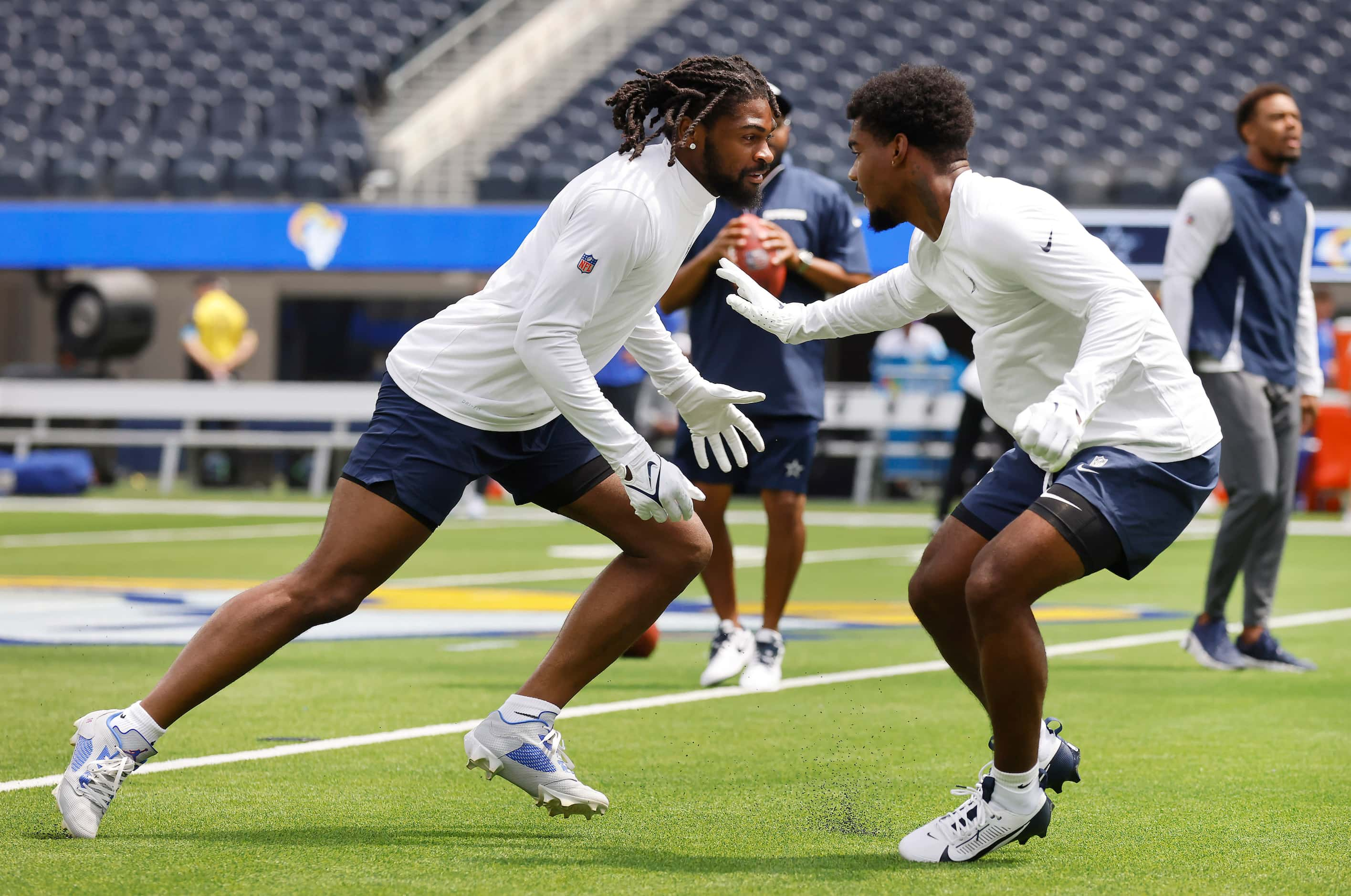 Dallas Cowboys cornerback Trevon Diggs (left) catches a pass as he warms up before the Los...