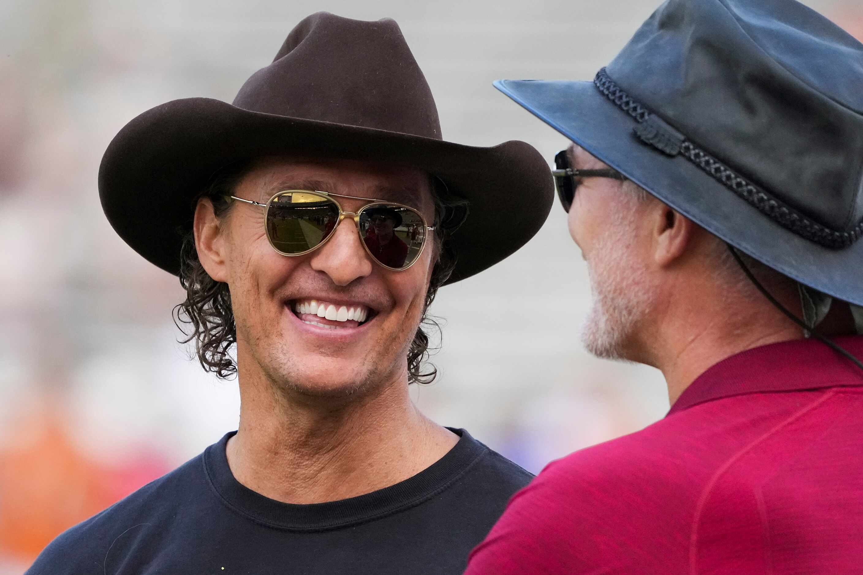 Actor Matthew McConaughey talks with former Oklahoma  player Brian Bosworth before the...