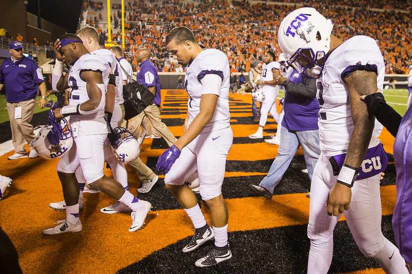 TCU quarterback Trevone Boykin (right) walks off with his teammates after a loss to Oklahoma...
