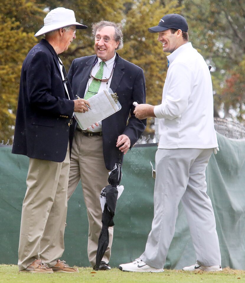 Dallas Cowboys quarterback Tony Romo (right) talks with tournament officials before starting...